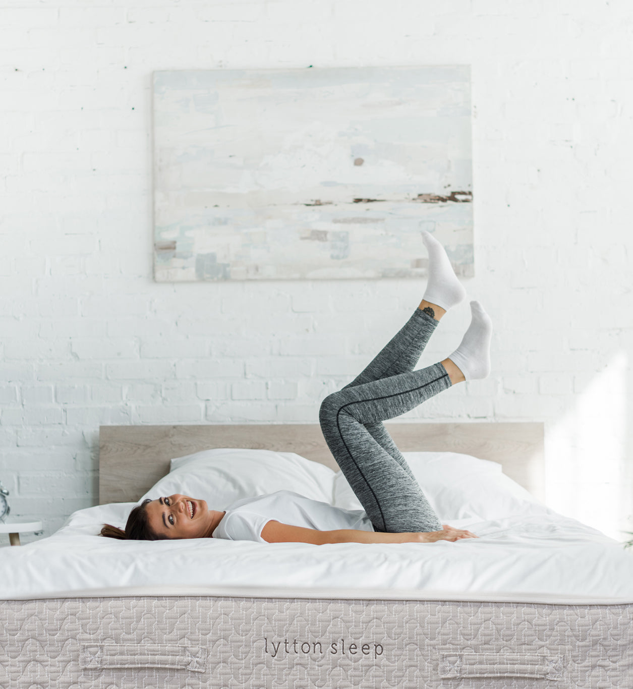 Woman in grey leggings laying on Lytton Mattress